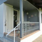 Die vormals dunkelbraune Veranda in Taubengrau. Eine neue Lampe und passende Bilder. Deko-Dinge wie eine Laterne.