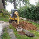 Kanalanschluss an unser Privathaus. Hier findet der erste "Spatenstich" statt. Von da an wurde über 100 Meter durch den Garten gegraben.